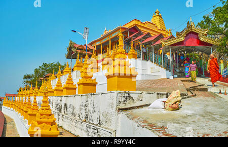 SAGAING, MYANMAR - 21. FEBRUAR 2018: Die Linien der goldenen Stupas in der U Min Thonze Höhlen, die überdachte Treppe hinter dem Schrein führt zum t Stockfoto