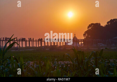 Die Silhouette von überfüllten U-Bein Brücke und Shwe Modeptaw Pagode auf Kupfer Sonnenuntergang in Amarapura, Myanmar. Stockfoto