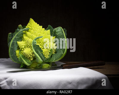 Romanische aka romanesco Brokkoli mit einem weißen Tuch und Messer. Immer noch leben, Nahrung. Broccoflower. Stockfoto