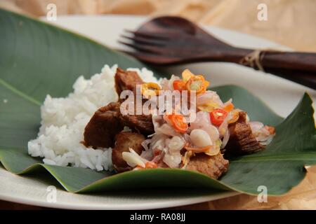 Babi Goreng Sambal Matah. Balinesisches Gericht von gebratenem Schweinefleisch Würfeln mit frischen salsa von Schalotten und Zitronengras. Stockfoto