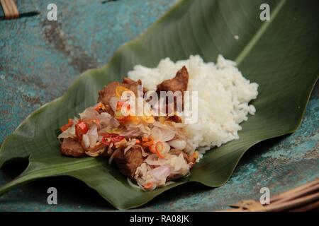 Babi Goreng Sambal Matah. Balinesisches Gericht von gebratenem Schweinefleisch Würfeln mit frischen salsa von Schalotten und Zitronengras. Stockfoto