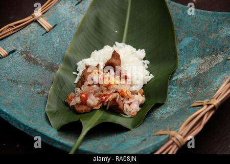 Babi Goreng Sambal Matah. Balinesisches Gericht von gebratenem Schweinefleisch Würfeln mit frischen salsa von Schalotten und Zitronengras. Stockfoto