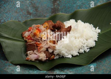 Babi Goreng Sambal Matah. Balinesisches Gericht von gebratenem Schweinefleisch Würfeln mit frischen salsa von Schalotten und Zitronengras. Stockfoto