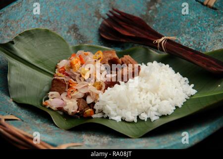 Babi Goreng Sambal Matah. Balinesisches Gericht von gebratenem Schweinefleisch Würfeln mit frischen salsa von Schalotten und Zitronengras. Stockfoto