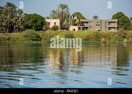 Blick über den großen breiten Fluss Nil in Ägypten Edfu durch ländliche Landschaft Landschaft mit afrikanischen Häuser am Flussufer Stockfoto