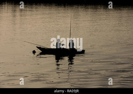 Silhouette des traditionellen ägyptischen Beduinen Angler im Ruderboot auf Nil bei Dämmerung Sonnenuntergang Stockfoto