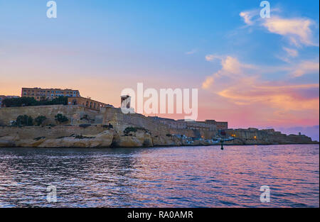 Romantischer Sonnenuntergang Yachtcharter Reise entlang Valletta Grand Harbour mit Blick auf die Wahrzeichen der Stadt, feurigen Himmel und dunklen Gewässern, Malta. Stockfoto