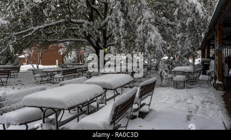 Picknicktische mit Schnee am leeren Cafe mit roten kein Eingang Schild im Hintergrund Stockfoto