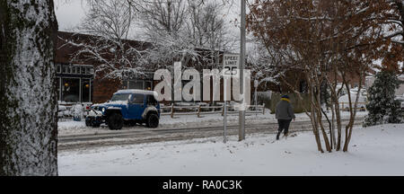 Frau zu Fuß entlang der Straße im tiefen Schnee mit dem Auto an der Seite der Straße geparkt Stockfoto