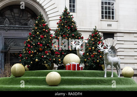 Jewel verkrustete Hirsch und Weihnachtsbaum mit Kugeln und Geschenke eingerichtet Stockfoto