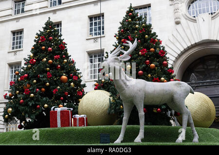 Jewel verkrustete Hirsch und Weihnachtsbaum mit Kugeln und Geschenke eingerichtet Stockfoto