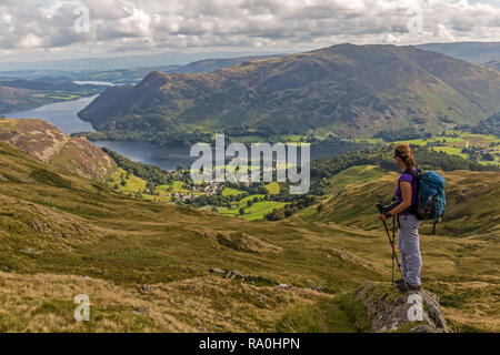 Weibliche Wanderer auf der Suche nach unten in Richtung Ullswater und Glenridding, im Lake District National Park in Cumbria, England. Stockfoto