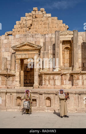 Zwei arabische Männer in traditionelle Jordanische dress spielen traditionelle Jordanische Instrumente, die in den Römischen Ruinen von Jerash in Jordanien. Stockfoto