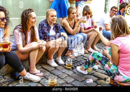 Straßenszene im Sommer Menschen Frauen trinken Bier außerhalb der Bar, Touristen genießen das Leben trinken Bier Spaziergang kurze Haltestelle Prag Tschechische Republik Stockfoto