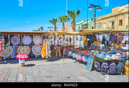 MARSAXLOKK, MALTA - 18. JUNI 2018: Der touristische Markt belegt den Teil der Strandpromenade und bietet eine breite Palette von verschiedenen Souvenirs, traditionelle Stockfoto