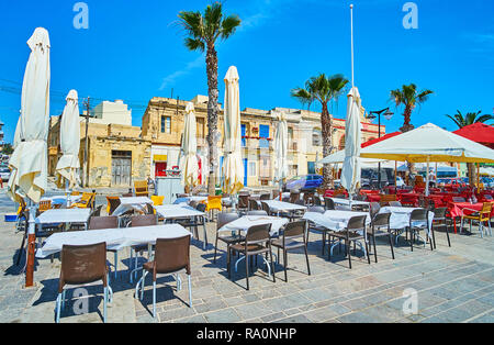 MARSAXLOKK, MALTA - 18. Juni 2018: Die Strandpromenade des Dorfes ist mit touristischen Cafés und gemütlichen Restaurants, beliebt bei den Ferien besetzt Stockfoto