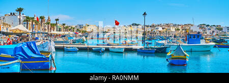 MARSAXLOKK, MALTA - 18. JUNI 2018: Panorama Resort aus seinem Hafen mit Blick auf die traditionelle maltesische Architektur hinter dem Hunderte von fishi Stockfoto