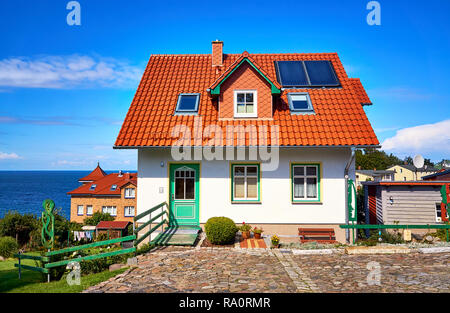 Neues, modernes Einfamilienhaus mit roten Dachziegeln und Solarkollektoren. Wohnzimmer mit Blick auf die Ostsee in Lohme auf der Insel Rügen. Stockfoto