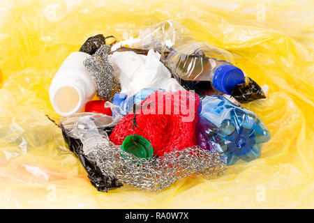 Plastik Müll mit leeren Plastikflaschen und anderen Müll auf gelbem Hintergrund aus Kunststoff Stockfoto