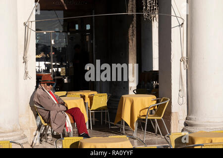 Reife männliche genießen Sie die Wintersonne am Markusplatz, Venedig, Italien. Stockfoto