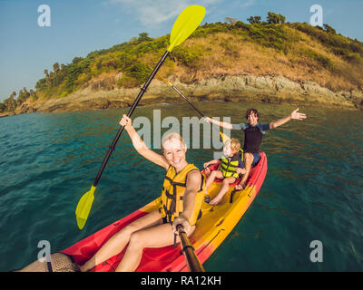 Glückliche Familie mit Kind Kajak im tropischen Ozean Stockfoto