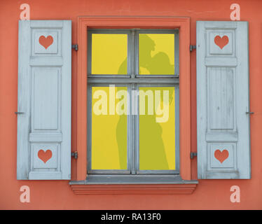 Beleuchtete Fenster Rahmen mit einer Silhouette von ein paar Liebe machen auf einem romantischen Tag, Valentines Tag Konzept Hintergrund Stockfoto