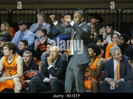 Stillwater, OK, USA. 29 Dez, 2018. Oklahoma State Head Coach Mike Boynton, Jr. feiert auf dem Nebenerwerb während ein Basketballspiel zwischen der Texas A&M University-Corpus Christi Inselbewohner und Oklahoma State Cowboys an Gallagher - Arena in Stillwater, OK. Grau Siegel/CSM/Alamy leben Nachrichten Stockfoto