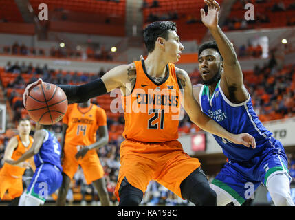 Stillwater, OK, USA. 29 Dez, 2018. Oklahoma State Guard Lindy Gewässer, III (21) schützt die Kugel während ein Basketballspiel zwischen der Texas A&M University-Corpus Christi Inselbewohner und Oklahoma State Cowboys an Gallagher - Arena in Stillwater, OK. Grau Siegel/CSM/Alamy leben Nachrichten Stockfoto