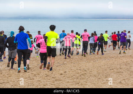 Bournemouth, Dorset, Großbritannien. Zum 30. Dezember 2018. Die Teilnehmer nehmen an den Strand Rennen, rennen die Gezeiten, Ebbe Strand entlang der wunderschönen Küste von Bournemouth Strand in Richtung Sandbänke Strand laufen. Läufer laufen die 5k- oder 10k Rennen an der Küste entlang und über die buhnen, bevor die Flut - gute Übung Nach den Exzessen der Weihnachten kommt! Credit: Carolyn Jenkins/Alamy leben Nachrichten Stockfoto