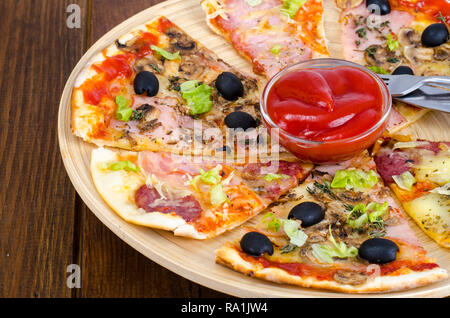 Sechs Scheiben Pizza mit verschiedenen Toppings auf Holzbrett. Studio Foto Stockfoto