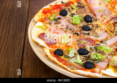 Sechs Scheiben Pizza mit verschiedenen Toppings auf Holzbrett. Studio Foto Stockfoto