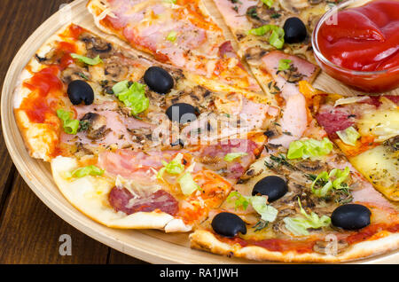 Sechs Scheiben Pizza mit verschiedenen Toppings auf Holzbrett. Studio Foto Stockfoto
