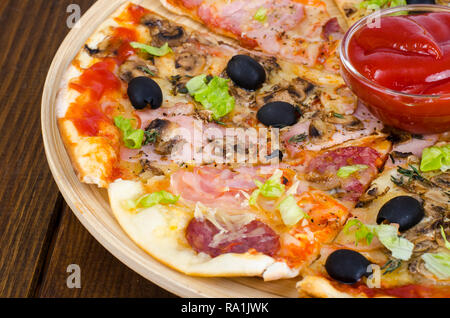 Sechs Scheiben Pizza mit verschiedenen Toppings auf Holzbrett. Studio Foto Stockfoto