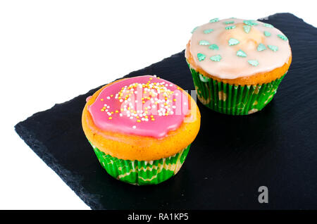 Zwei selbstgemachte mini Cupcakes mit farbiger Zuckerglasur. Studio Foto Stockfoto