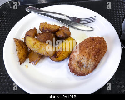 Weiße Platte mit Schichten von gebackenen Kartoffeln und Fleisch Schnitzel. Studio Foto Stockfoto