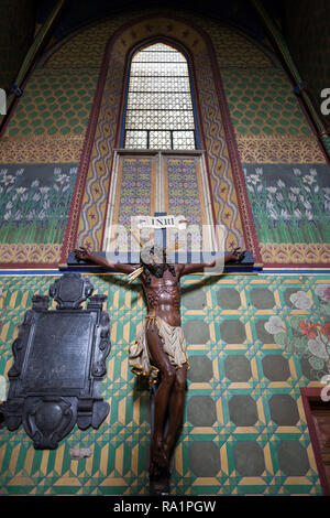 Jesus Christus am Kreuz, Kruzifix an der Wand mit vielfarbigen Gemälden in der Basilika des Hl. Franziskus von Assisi in Krakau, Polen, Kirche zurück Stockfoto