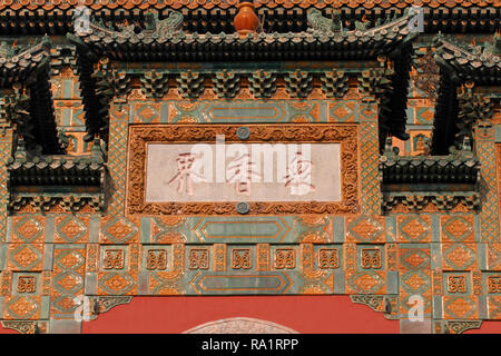 Chinesische Schrift auf einer Plakette, in eine glasierte Fliesen- Gebäude im Sommerpalast, Peking, China eingebettet. Halle auf das Meer der Weisheit Stockfoto