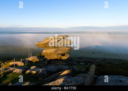 Die ersten Strahlen der aufgehenden Sonne Ausleuchten der Cheesewring Steine auf Stowe Hill als Nebel fegt über Bodmin Moor, Cornwall, Großbritannien Stockfoto