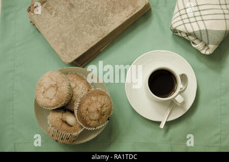 Sicht von oben mit Flach Stil, ein Snack mit Kaffee, Muffins und ein gutes Buch für entspannende Momente Stockfoto