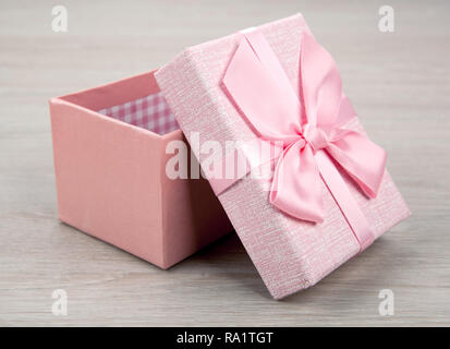 Öffnen pink Geschenkverpackung auf hölzernen Hintergrund Nahaufnahme Stockfoto