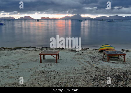 Sonnenuntergang über Bacuit Corong Corong Bay wie vom Strand mit Blick auf Matinloc-Miniloc - Shimizu-Inatula - Entalula-Pangulasian - Popolcan Inseln gesehen. Holztische-o Stockfoto