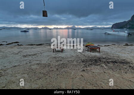 Sonnenuntergang über Bacuit Corong Corong Bay wie vom Strand mit Blick auf Matinloc-Miniloc - Shimizu-Inatula - Entalula-Pangulasian - Popolcan Inseln gesehen. Holztische-o Stockfoto