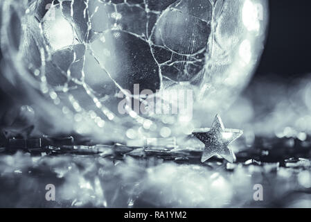 Makro Foto von gerissenen glas kugel Silver Star mit Licht bokeh Stockfoto