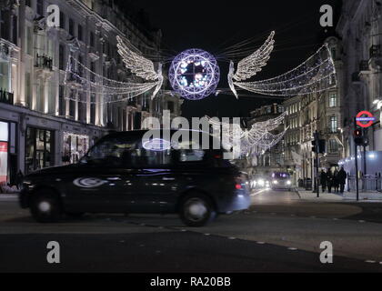 Wenige Tage vor Weihnachten in London. Spät in der Nacht auf fast leeren der Oxford Street in London. Mit wenigen berühmten schwarzen Kappen. Stockfoto