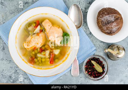 Fischsuppe mit Gemüse und Lachs in weiße Platte auf grauem Hintergrund. Studio Foto Stockfoto