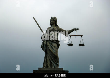 Statue von Themis, Göttin der Gerechtigkeit auf einem grau-blauen Hintergrund Stockfoto