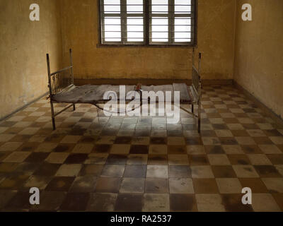 Eines der Zimmer mit Bett und Fesseln, wo die Opfer des mörderischen Roten Khmer in Tuol Sleng Genozidmuseum Stadtrand Phnom Penh Kambodscha gefoltert wurden EIN Stockfoto