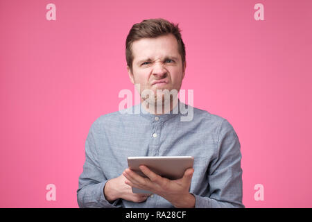 Zornigen Mann mit einem Tablett auf einem rosa Hintergrund Stockfoto