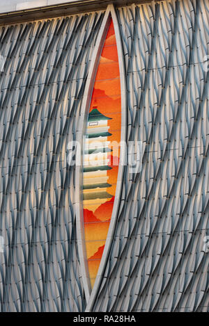 Eine dramatische Schlitz in der kurvenförmigen Fassade von Hong Kongs Xiqu Center zeigt eine traditionelle chinesische Pagode und Landschaft Stockfoto