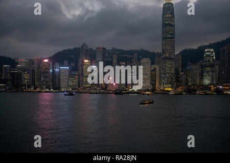 Schwere wolken Webstuhl über dem glitzernden Türmen von Hong Kong Central District als Nacht rollt. Stockfoto